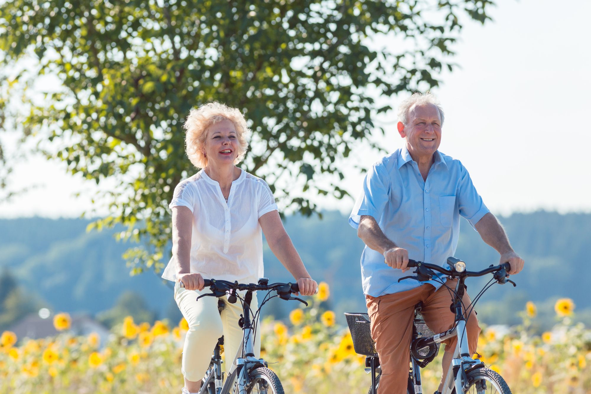 Senior couple biking after pain relief treatment with ARP Wave therapy