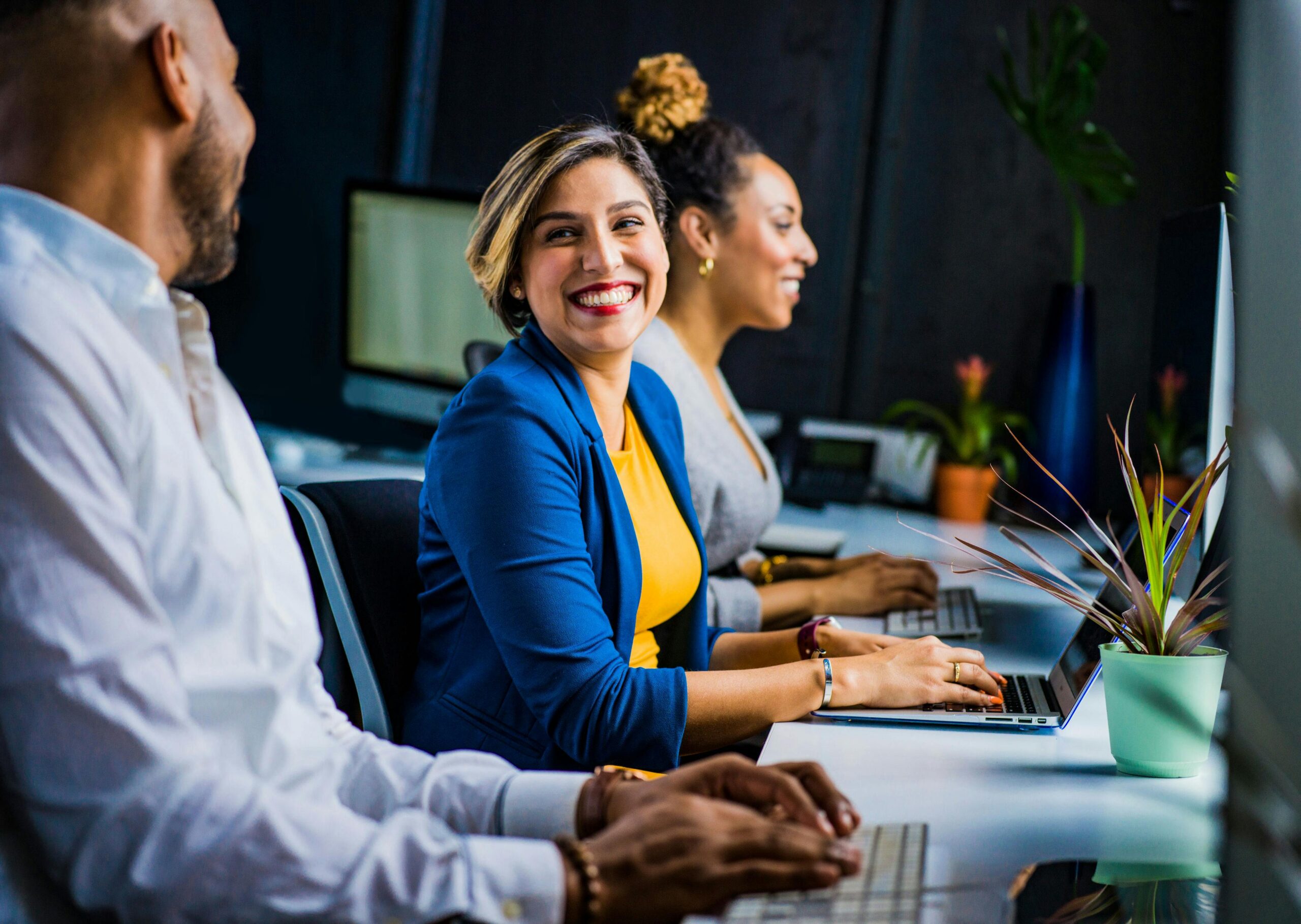 Smiling professionals working comfortably at modern office desks